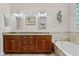Elegant bathroom features a double vanity with granite countertops, a soaking tub, and stylish fixtures at 131 Wimbledon Cir, Lake Mary, FL 32746