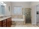 Bathroom showcasing tiled walls, glass block window, walk-in shower and a soaking tub with tile surround at 131 Wimbledon Cir, Lake Mary, FL 32746