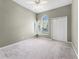 Light-filled bedroom with large windows, neutral walls, ceiling fan, and a sliding door closet at 131 Wimbledon Cir, Lake Mary, FL 32746
