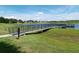 A fishing pier with railings on the water and a grassy shoreline under a clear sky at 131 Wimbledon Cir, Lake Mary, FL 32746