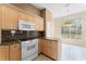 Eat-in kitchen featuring granite countertops, natural wood cabinetry, and stainless steel appliances at 131 Wimbledon Cir, Lake Mary, FL 32746