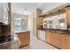 Eat-in kitchen featuring granite countertops, natural wood cabinetry, and stainless steel appliances at 131 Wimbledon Cir, Lake Mary, FL 32746