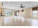 Bright living room boasts tile flooring, large windows, and sliding glass door to the outside at 131 Wimbledon Cir, Lake Mary, FL 32746