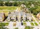 Aerial view of a tan townhome with a brown roof, with parking, landscaping and a golf course at 1322 Seven Eagles Ct # 301, Reunion, FL 34747