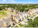 Aerial view of tan townhomes with brown roofs, surrounded by green landscaping and mature trees at 1322 Seven Eagles Ct # 301, Reunion, FL 34747