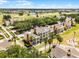 Aerial view of beautiful tan condos overlooking a lush golf course and serene lake at 1322 Seven Eagles Ct # 301, Reunion, FL 34747