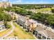Aerial view showcases tan townhomes near a golf course and other community features at 1322 Seven Eagles Ct # 301, Reunion, FL 34747