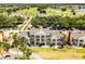 Aerial view of tan townhomes with a brown roof, near a golf course and waterway at 1322 Seven Eagles Ct # 301, Reunion, FL 34747