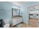 Bright bathroom with granite counters, white cabinets, a large mirror, and an adjacent kitchen at 1322 Seven Eagles Ct # 301, Reunion, FL 34747