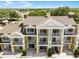 Exterior view of a yellow townhome with a brown roof, with multiple balconies at 1322 Seven Eagles Ct # 301, Reunion, FL 34747