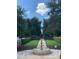 Beautiful fountain in a well-manicured garden with symmetrical landscaping and walking paths at 1322 Seven Eagles Ct # 301, Reunion, FL 34747