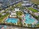 Stunning aerial view of the community pool, cabanas, and landscaping with palm trees in this resort-style neighborhood at 13241 Cormack Ln, Orlando, FL 32827
