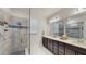 Modern bathroom featuring a glass-enclosed shower with dual sinks, sleek cabinetry, and elegant finishes, creating a spa-like experience at 13241 Cormack Ln, Orlando, FL 32827