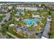 Aerial view showcases the luxurious community pool with palm trees, lounge chairs, and a splash pad at 13241 Cormack Ln, Orlando, FL 32827