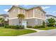 Charming two-story home featuring a landscaped yard with lush green grass and mature trees at 13241 Cormack Ln, Orlando, FL 32827