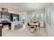 Well-lit kitchen flowing to a dining area with stainless appliances, dark cabinets, and island seating at 13241 Cormack Ln, Orlando, FL 32827