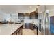 Modern kitchen features stainless steel appliances, dark cabinets, and white countertops open to the living area at 13241 Cormack Ln, Orlando, FL 32827