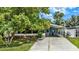 Charming blue home featuring a well-maintained lawn and a driveway, shaded by mature trees at 133 Moss Dr, Debary, FL 32713