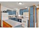 Bright kitchen featuring ample blue cabinetry, white appliances, and a convenient center island prep area at 133 Moss Dr, Debary, FL 32713