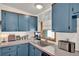 Bright kitchen with blue cabinets, modern appliances, and a stainless steel sink at 133 Moss Dr, Debary, FL 32713