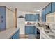 Cozy kitchen featuring blue cabinetry, updated appliances and a view of the living space at 133 Moss Dr, Debary, FL 32713