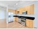 Modern kitchen featuring stainless steel appliances, wood cabinets, and a black countertop at 150 E Robinson St # 4A, Orlando, FL 32801