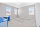 Bedroom featuring carpeted floors, three windows and neutral walls with a blue desk at 16753 Gullfloss Ter, Winter Garden, FL 34787