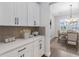 Well-lit butler's pantry with white cabinets, quartz countertops, and backsplash at 16753 Gullfloss Ter, Winter Garden, FL 34787