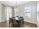 Dining room featuring wood-look tile floors, modern chandelier and elegant patterned curtains at 16753 Gullfloss Ter, Winter Garden, FL 34787