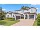 Two-story home featuring an attached two-car garage, arched entryway, and well-maintained landscaping at 16753 Gullfloss Ter, Winter Garden, FL 34787