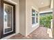 Covered front porch with brick flooring and decorative front door for a welcoming entrance at 16753 Gullfloss Ter, Winter Garden, FL 34787