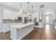 Modern kitchen with white cabinets, stainless steel appliances, center island, and dark wood floors at 16753 Gullfloss Ter, Winter Garden, FL 34787
