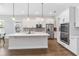 Bright, modern kitchen with white cabinets, stainless steel appliances, a center island and dark wood floors at 16753 Gullfloss Ter, Winter Garden, FL 34787