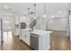 Modern kitchen with white cabinets, stainless steel appliances, a center island, and hardwood floors at 16753 Gullfloss Ter, Winter Garden, FL 34787