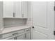 Bright butler's pantry boasts quartz countertops and modern white cabinetry at 16753 Gullfloss Ter, Winter Garden, FL 34787