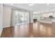 Bright and open living room featuring hard wood floors, large windows, and seamless transition to the kitchen and dining area at 16753 Gullfloss Ter, Winter Garden, FL 34787