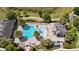 Aerial view of a community pool featuring palm trees, an outdoor lounge area, and a covered pavilion at 16753 Gullfloss Ter, Winter Garden, FL 34787
