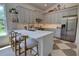 Bright kitchen with stone backsplash, breakfast bar, stainless steel appliances, gray cabinets, and wood floors at 1740 Cherry Ridge Dr, Lake Mary, FL 32746