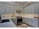 Bright kitchen with stone backsplash, stainless steel appliances, gray cabinets, under cabinet lighting and wood floors at 1740 Cherry Ridge Dr, Lake Mary, FL 32746