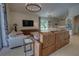 Bright living room, connected to the kitchen, features wood floors, brown leather sofa and view to outdoors at 1740 Cherry Ridge Dr, Lake Mary, FL 32746