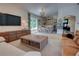 Bright living room, connected to the kitchen, features wood floors, brown leather sofa and view to outdoors at 1740 Cherry Ridge Dr, Lake Mary, FL 32746