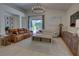 Bright living room with vaulted ceiling, modern chandelier, leather sofa and view to backyard pool at 1740 Cherry Ridge Dr, Lake Mary, FL 32746