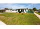 Exterior view of a cozy home with green lawn, walkway, and tidy landscaping on a sunny day at 1831 Aaron Ave, Orlando, FL 32811