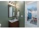 Stylish half bath with modern vanity, mirror, and convenient access to other living spaces at 2004 Fleming Mist Pl, Kissimmee, FL 34747