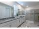 Modern bathroom with dual sinks, granite countertops, and a glass-enclosed shower at 2004 Fleming Mist Pl, Kissimmee, FL 34747
