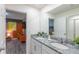 A well-lit double sink bathroom with large mirror and granite countertop at 2004 Fleming Mist Pl, Kissimmee, FL 34747