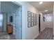 Bright hallway with wood-look floors, artwork on the walls, and access to multiple rooms at 2004 Fleming Mist Pl, Kissimmee, FL 34747