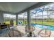 Inviting screened-in patio featuring comfortable seating, a grill, and a refreshing pool with an attached spa at 2004 Fleming Mist Pl, Kissimmee, FL 34747