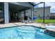 Outdoor pool area featuring a covered patio, lounge chairs, and lush landscaping at 2004 Fleming Mist Pl, Kissimmee, FL 34747