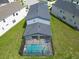 Aerial view of private screened-in pool and spa with a brick paver deck in backyard at 2004 Fleming Mist Pl, Kissimmee, FL 34747